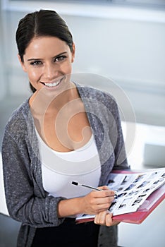 She has an eye for great images. Portrait of a young design professional holding some contact sheets and smiling at the photo
