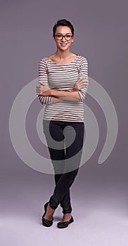 She has looks and brains. Studio shot of a casually dressed woman against a gray background.