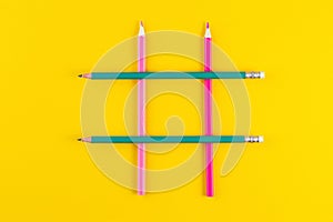 Hashtag sign from crossed colorful pencils on yellow background