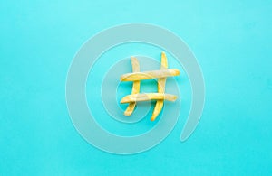 Hashtag sign icon with french fried on blue color background.Food, nutrition and social conversation concepts