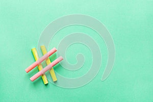 Hashtag Sign Made from Crossed Colorful Pink Yellow Chalks Crayons on Turquoise Background. Social Media Networking Blogging