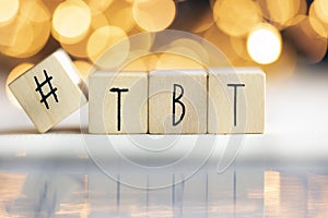 Hashtag TBT throwback Thursday written with wooden cubes with shiny bokeh background, social media concept photo