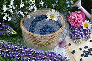 Haskap or honeysuckle berry in the wicker basket on the wooden planks.