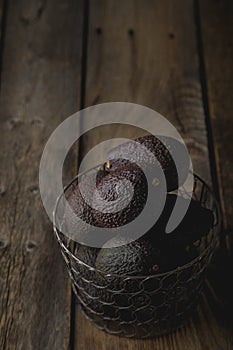 Hass avocado in a basket on a wooden table