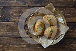 Hasselblad potatoes oven  baked with spices and olive oil on dark wooden table photo