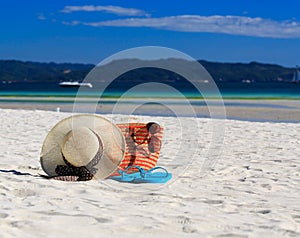 Hat, bag, sun glasses and flip flops on tropical beach