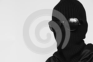 Hat balaclava on a girl and sunglasses on a white background, the face of a thief in a hat with a slit for verbs, a hacker