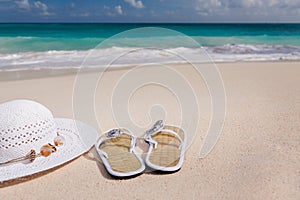 Hat and flip-flops on the beach