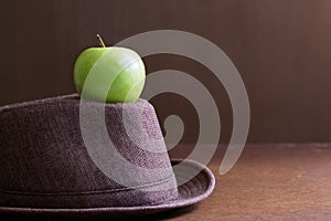 Hat and green apples in the room with the light and shadow is be