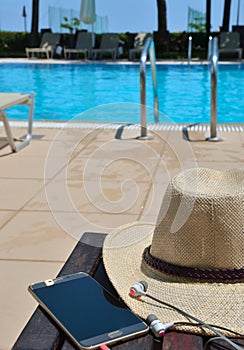 Hat with mobile phone and headphones on the green grass