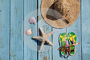 Hat, sandals, seashells and starfish on the blue background.