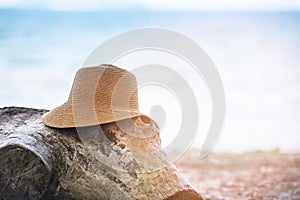 hat summer Straw hat fasion on log at beach sea background photo