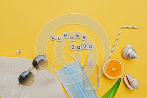 Hat, sunglasses,medical protective mask, spray, shells, citrus fruits and straw tubes, lettering summer 2020 in square wooden