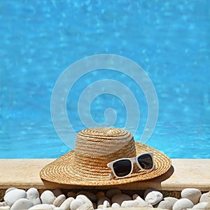 Hat and sunglasses by the poolside