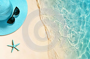 Hat and sunglasses on the sandy beach. Summer background