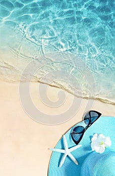 Hat and sunglasses on the sandy beach. Summer background