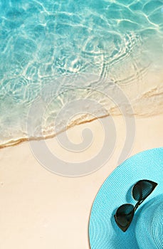 Hat and sunglasses on the sandy beach. Summer background