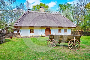 The hata house and old wooden cart in Potter`s estate, Mamajeva Sloboda Cossack Village, Kyiv, Ukraine