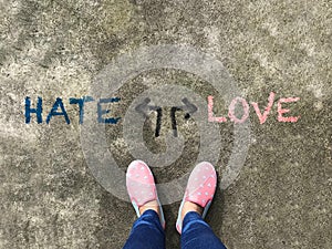 Hate or Love arrow and pink slipper shoe on concrete background