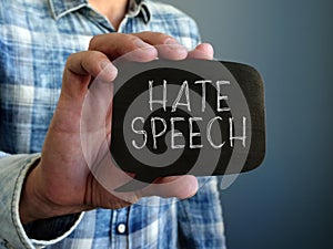Hate speech concept. A hand holds a black plate.