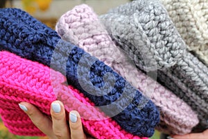 Hats crocheted knitted in the hands of a girlon the street. Product listing for sale. Urban style. Fashion. Autumn