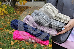 Hats crocheted knitted in the hands of a girlon the street. Product listing for sale. Urban style. Fashion. Autumn