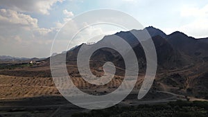 Hatta mounains and the city sign in Hajar mountains in the enclave of Dubai in the UAE