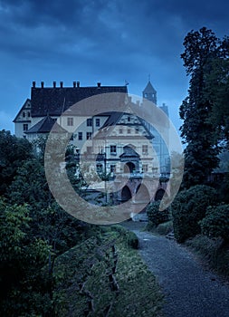 Haunted castle in mist at Halloween night, old spooky mansion at dusk