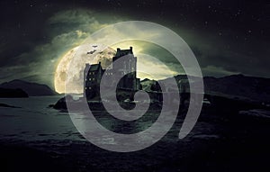 Haunted mystic eerie Eilean Donan Castle in Scotland with the sea around it dark clouds and the moon