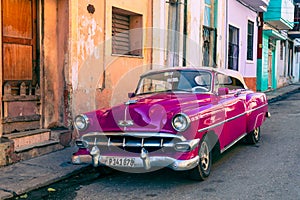 HAVANA, CUBA - DECEMBER 10, 2019: Havana Cuba Classic Cars. Typcal Havana urban scene with colorful buildings and old cars