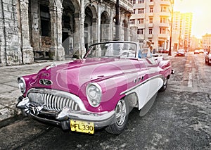 HAVANA- JANUARY 27, 2013: The beautiful woman at a wheel old American retro car 50th years of the last century, an iconic sight