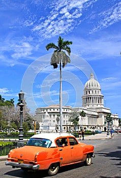 HavanaÂ´s Capitolio with orange vintage car, Cuba