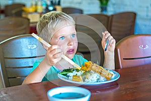 Have a break. Vegetarian food can be delicious for everybody. Boy eat rice and stew vegetables in white plate with