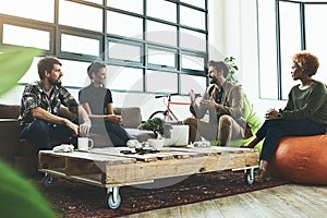 They have a creative knack for getting things done. a group of young designers having a discussion in a modern office.