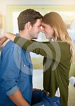 They only have eyes for each other. an affectionate young couple hugging in their kitchen.