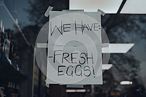 `We have fresh eggs` sign outside a shop.