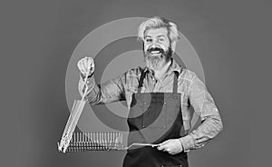Have fun enjoy cooking. Hipster dyed beard promoting bbq equipment. Cooking healthy. Tools roasting meat. Man in apron
