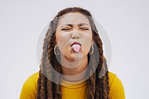 Have fun and lots of it. Studio shot of a young woman making a funny face against a gray background.