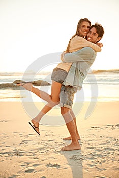They always have fun together. Full length shot of a young couple being playful at the beach.