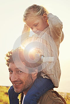 They have the most fun together. Shot of a father carrying his little girl on his shoulders while walking outdoors.