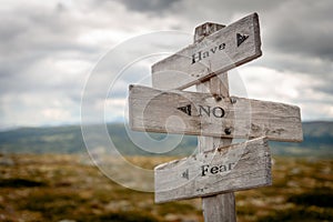 have no fear text engraved on old wooden signpost outdoors in nature