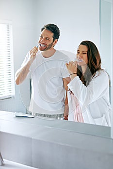 We have no problem with sharing our personal space. a couple brushing their teeth in the bathroom at home together.