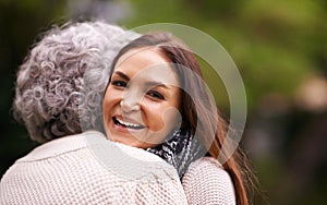 They have the perfect mother-daughter relationship. an attractive woman and her senior mother hugging outside.