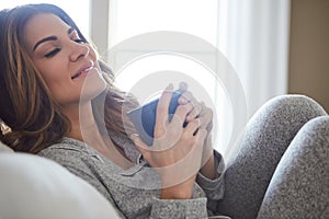 Have a pyjama day and leave the slay for tomorrow. a beautiful young woman having coffee during a relaxing morning at