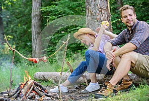 Have snack. Picnic roasting food over fire. Cooking at picnic. Girl offers eat apple while they waiting roasted food