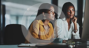 They have some tasks to complete this evening. two young businesswomen working together on a computer in an office at