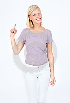 Have you seen this deal. Happy young woman pointing upwards while isolated on white.