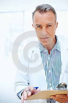 We have your prognosis. Serious look from doctor while he holds clients chart.