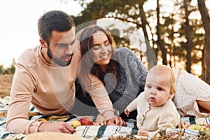 Haves picnic. Happy family of mother, family and little baby rests outdoors. Beautiful sunny autumn nature