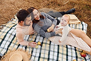 Haves picnic. Happy family of mother, family and little baby rests outdoors. Beautiful sunny autumn nature